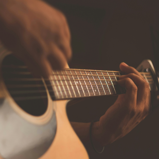 Billede af hænder, der spiller guitar. 