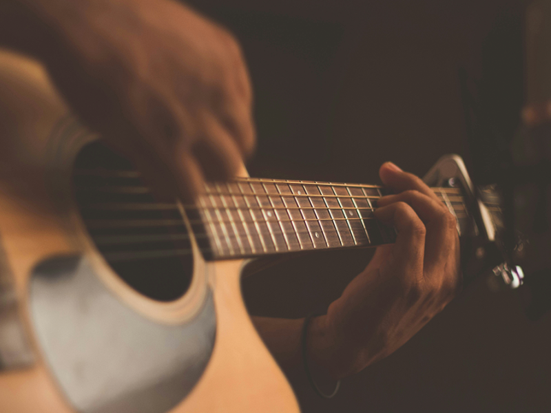 Billede af hænder, der spiller guitar. 