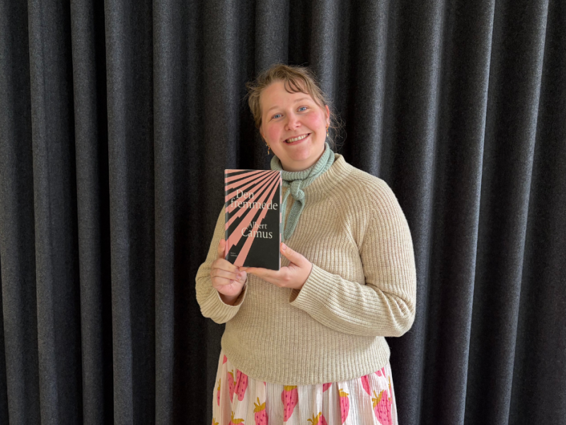 Litteraturformidler Imone Kramer holder bogforside med "Den fremmede"